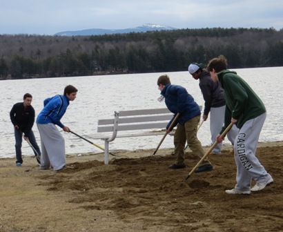 boys raking at beach
