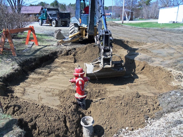 backhoe digging out hydrant