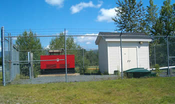 red pump next to white pump station building.