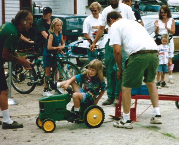 girl competing in toy tractor pull