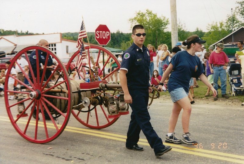 fire volunteers pulling antique hose cart