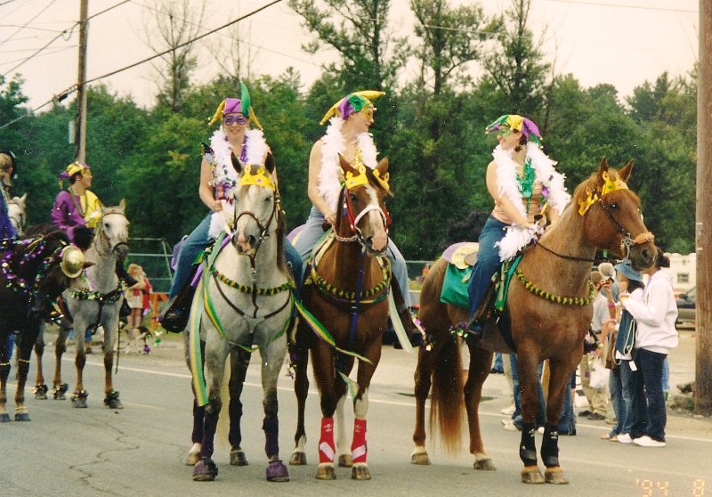 women dressed in mardi gras costumes on horses