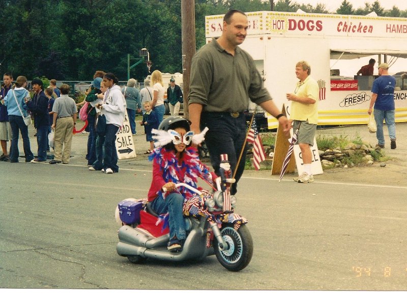 child dressed in mardi gras costume on mini motorcycle