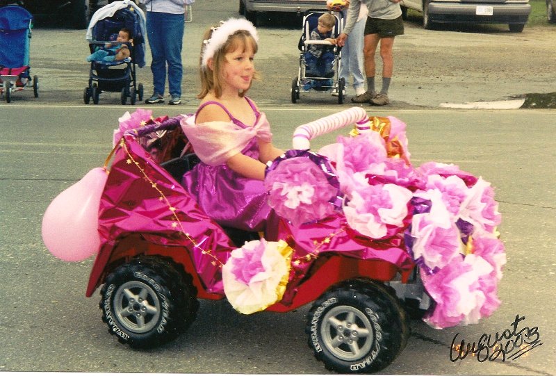 girl dressed in princess in small child's jeep