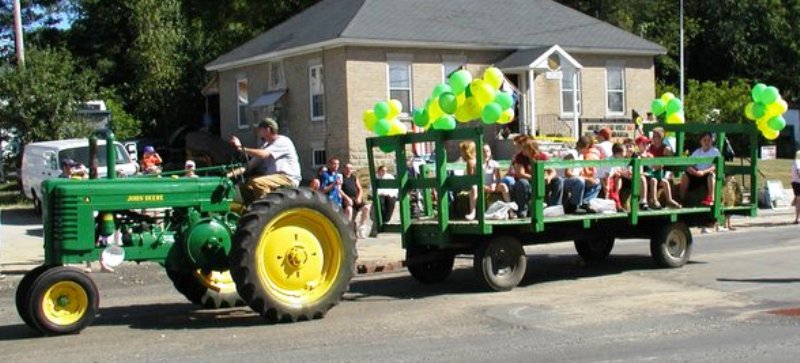 John Deere tractor pulling a float filled with children