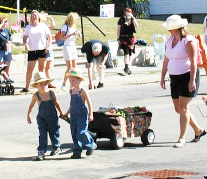 2 boys in overalls pulling a cart
