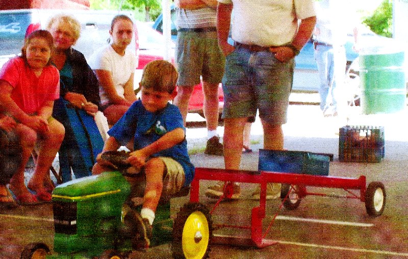 boy competing in toy tractor pull