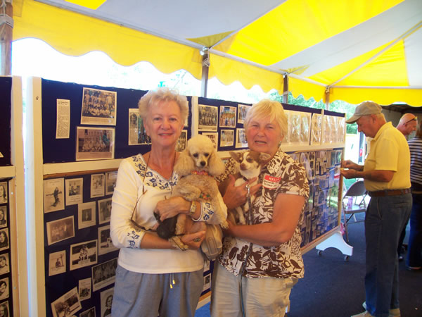 2 alumni women holding small dogs posing for photo